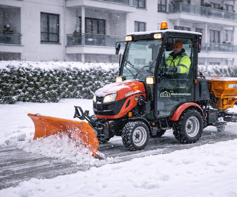 Räumfahrzeug mit Schneeschild und Streuer im Einsatz